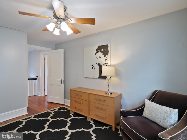 sitting room featuring ceiling fan, baseboards, and wood finished floors