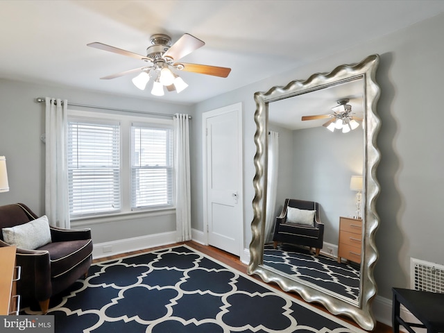 sitting room with visible vents, ceiling fan, baseboards, and wood finished floors