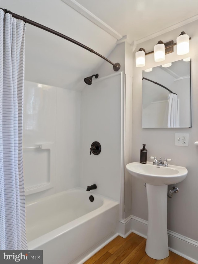 full bathroom with shower / tub combo, wood finished floors, and baseboards