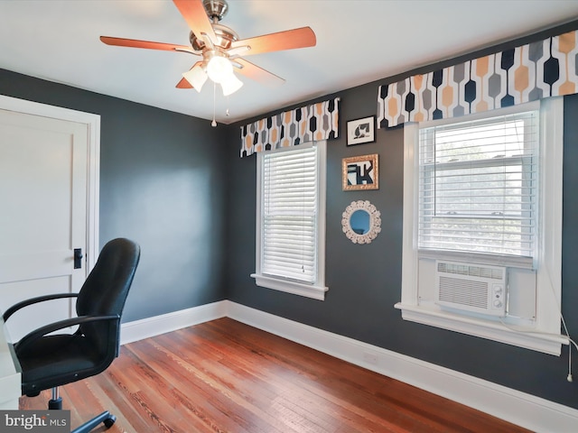 home office with cooling unit, wood finished floors, and baseboards