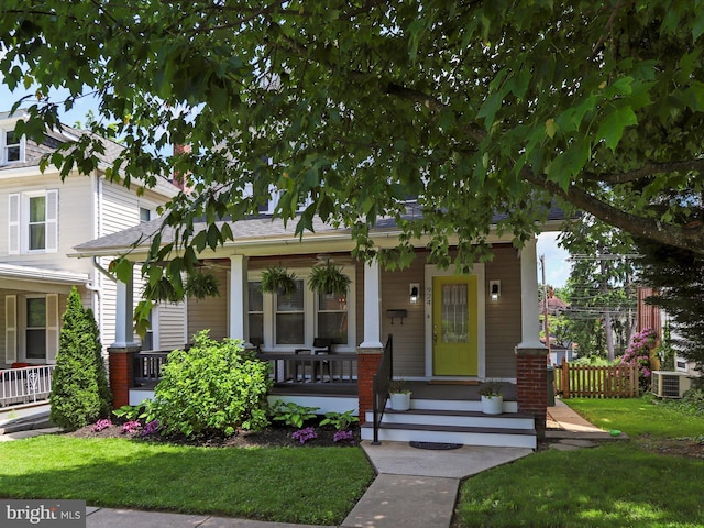 view of front of property featuring fence, a porch, cooling unit, and a front yard