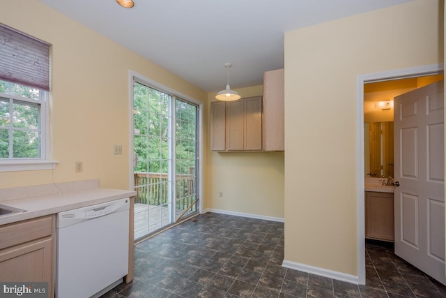 kitchen with baseboards, dishwasher, decorative light fixtures, light countertops, and light brown cabinetry