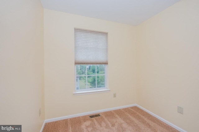 carpeted spare room featuring visible vents and baseboards