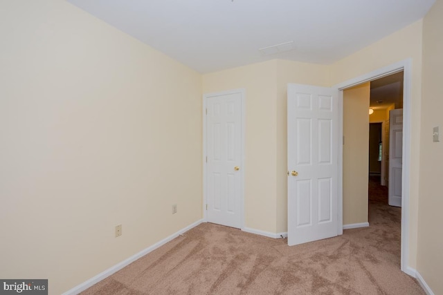 unfurnished bedroom with light carpet and baseboards