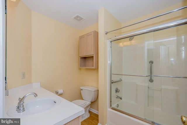 full bathroom featuring enclosed tub / shower combo, toilet, vanity, and visible vents