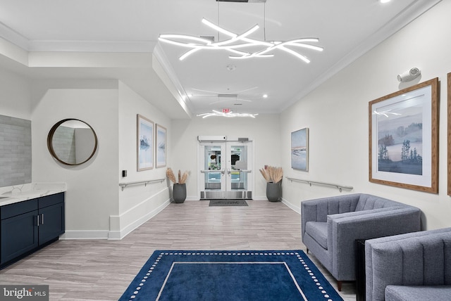 interior space featuring baseboards, french doors, light wood-style flooring, and crown molding