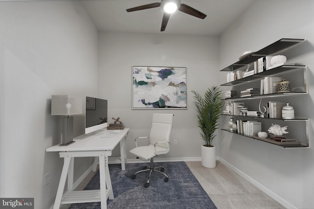 carpeted home office with a ceiling fan and baseboards