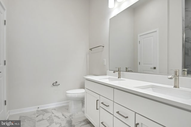 full bathroom with marble finish floor, a sink, baseboards, and double vanity