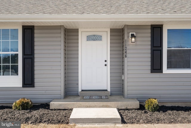 entrance to property featuring a shingled roof