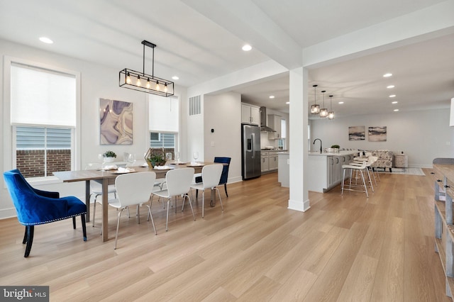 dining space with light wood-type flooring, visible vents, and recessed lighting