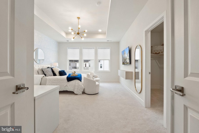 bedroom with a tray ceiling, light carpet, baseboards, and an inviting chandelier