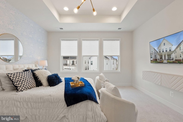 bedroom featuring carpet floors, a tray ceiling, baseboards, and wallpapered walls