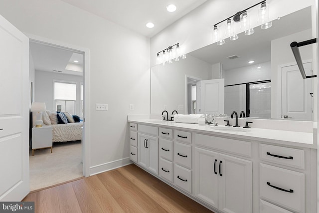 full bath featuring a sink, ensuite bath, wood finished floors, and a shower stall