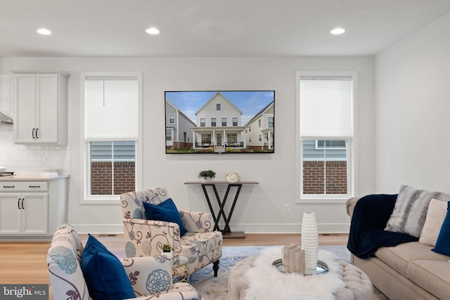 living area featuring light wood-type flooring, baseboards, and recessed lighting