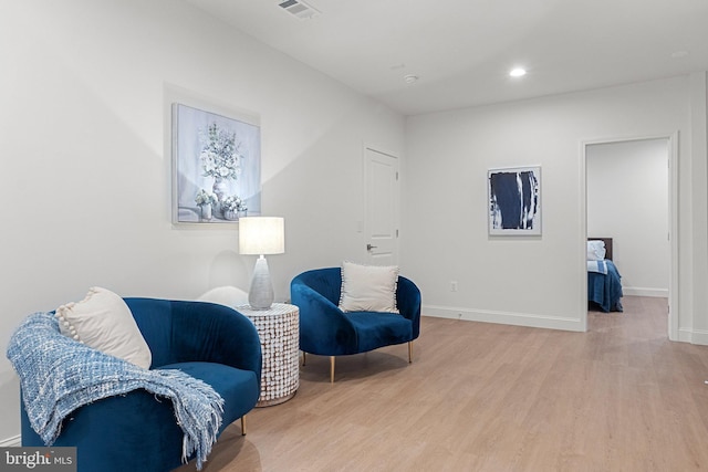 living area with recessed lighting, baseboards, visible vents, and light wood finished floors