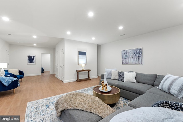 living area with light wood-style floors, visible vents, baseboards, and recessed lighting