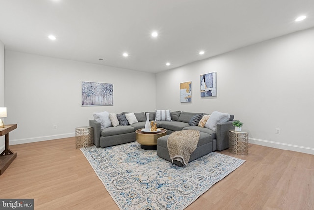 living room with light wood-style floors, recessed lighting, and baseboards