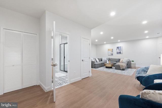 living area featuring baseboards, light wood-style flooring, and recessed lighting