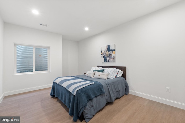 bedroom with recessed lighting, light wood-type flooring, visible vents, and baseboards