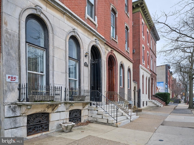 doorway to property featuring stone siding and brick siding