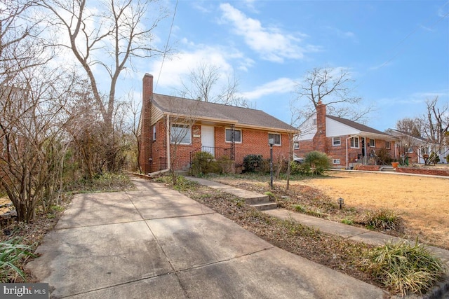 single story home featuring brick siding and a chimney