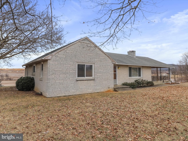 view of front of house featuring stone siding, a chimney, and brick siding