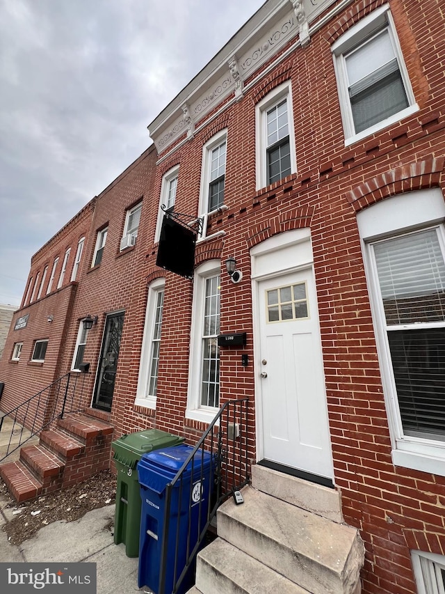 view of front of home featuring entry steps and brick siding