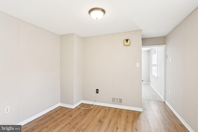 unfurnished room with visible vents, baseboards, and wood finished floors