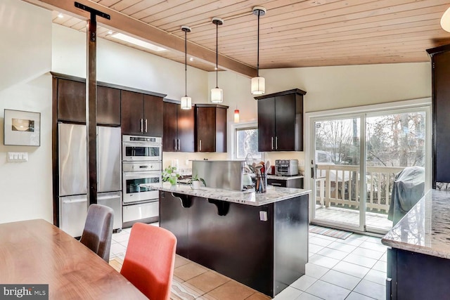 kitchen with light tile patterned floors, stainless steel appliances, dark brown cabinetry, and light stone countertops