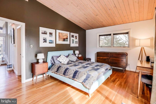 bedroom with wood ceiling, baseboards, vaulted ceiling, and wood finished floors