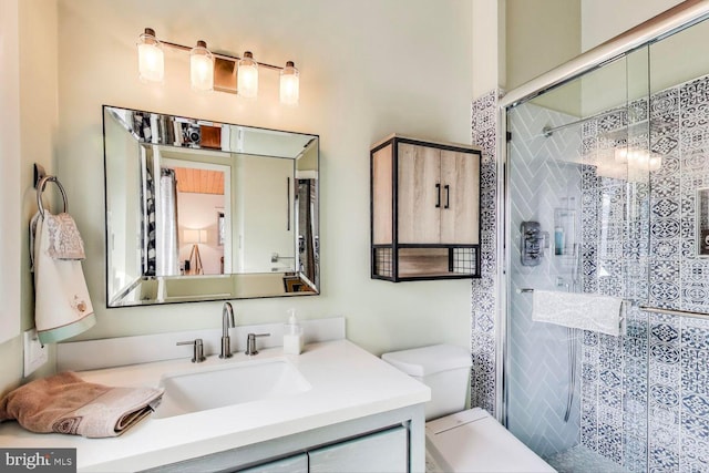 full bathroom featuring a stall shower, vanity, and toilet