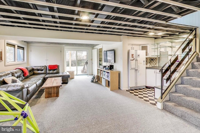 carpeted living room featuring a healthy amount of sunlight and stairs