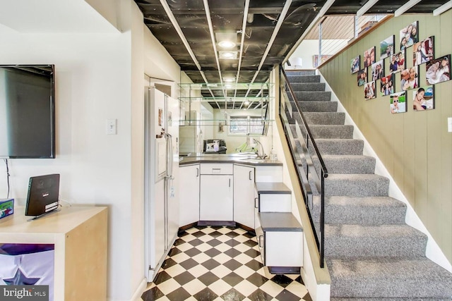 staircase featuring wood walls and tile patterned floors