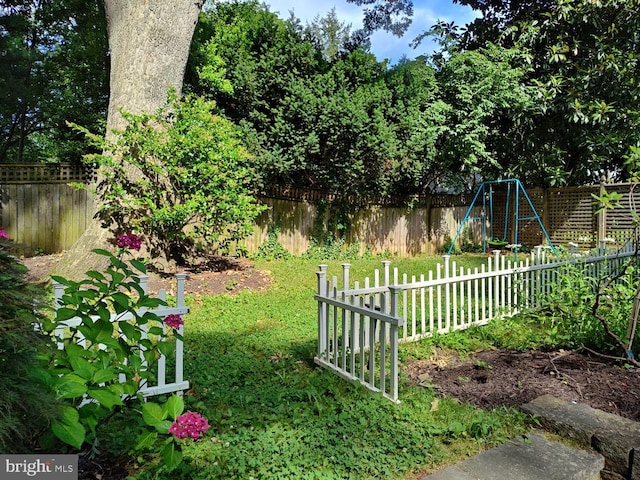 view of yard with a fenced backyard and a playground