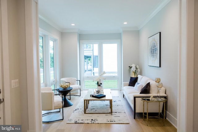 living room featuring light wood-type flooring, ornamental molding, and recessed lighting