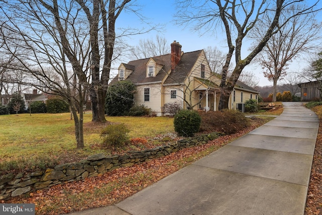 view of side of property featuring a lawn and a chimney