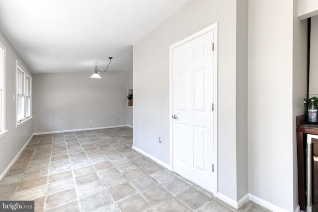 unfurnished room with baseboards