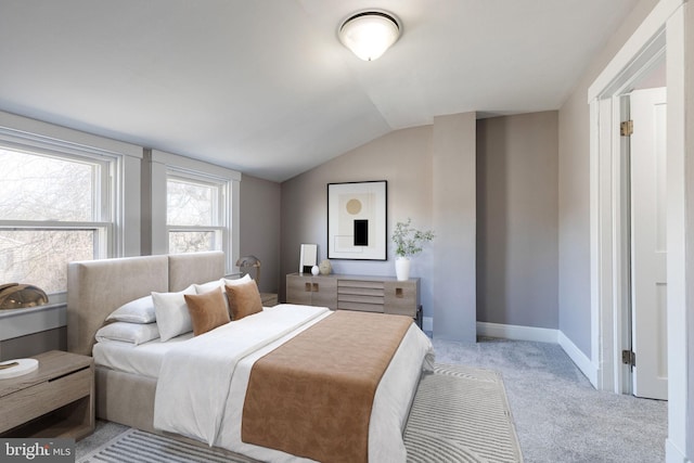 bedroom with light carpet, baseboards, and vaulted ceiling