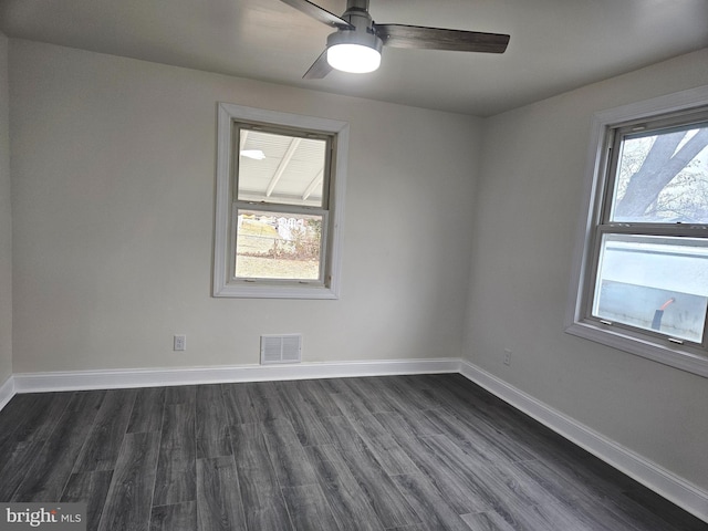 unfurnished room featuring a ceiling fan, baseboards, visible vents, and dark wood-style flooring