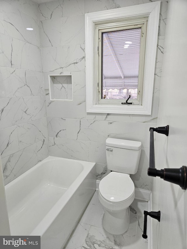 bathroom with toilet, marble finish floor, and a bathing tub