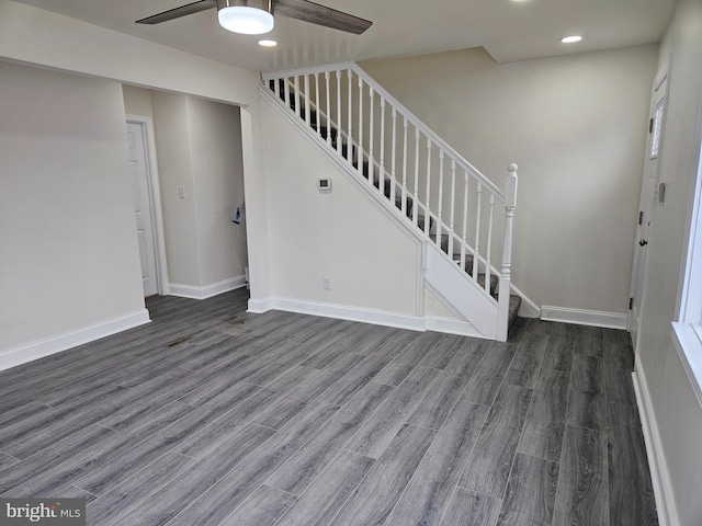 interior space featuring ceiling fan, stairway, dark wood finished floors, and baseboards