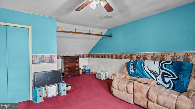 interior space with visible vents, wainscoting, ceiling fan, vaulted ceiling, and carpet flooring