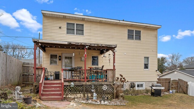 rear view of house featuring a fenced backyard and a wooden deck