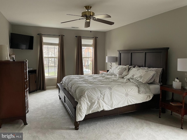 bedroom featuring ceiling fan, visible vents, and light colored carpet