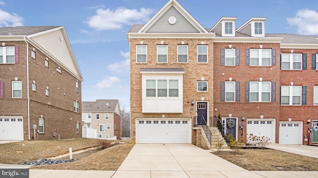 multi unit property featuring concrete driveway, brick siding, and an attached garage