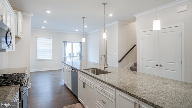 kitchen featuring light stone counters, appliances with stainless steel finishes, dark wood-type flooring, white cabinets, and a sink