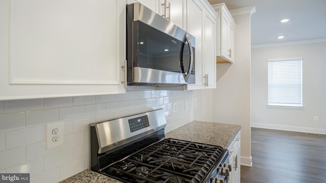 kitchen with stainless steel appliances, white cabinets, backsplash, light stone countertops, and crown molding