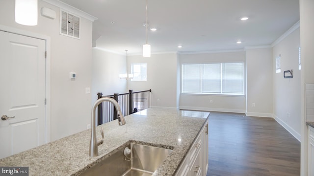 kitchen with dark wood-style flooring, a sink, white cabinetry, visible vents, and crown molding