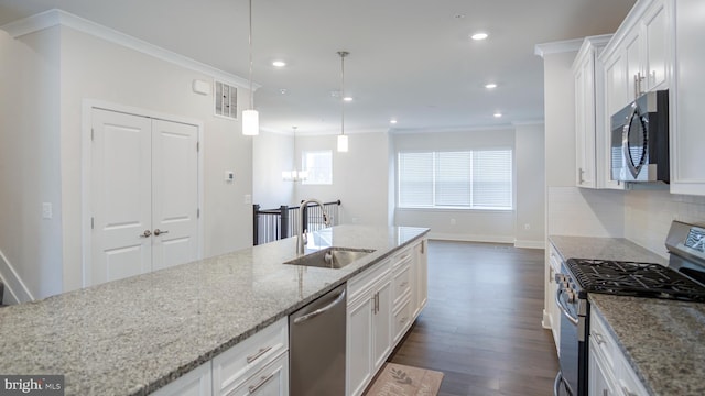 kitchen with visible vents, a sink, stainless steel appliances, crown molding, and backsplash