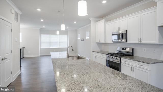 kitchen featuring stainless steel appliances, ornamental molding, a sink, and decorative backsplash